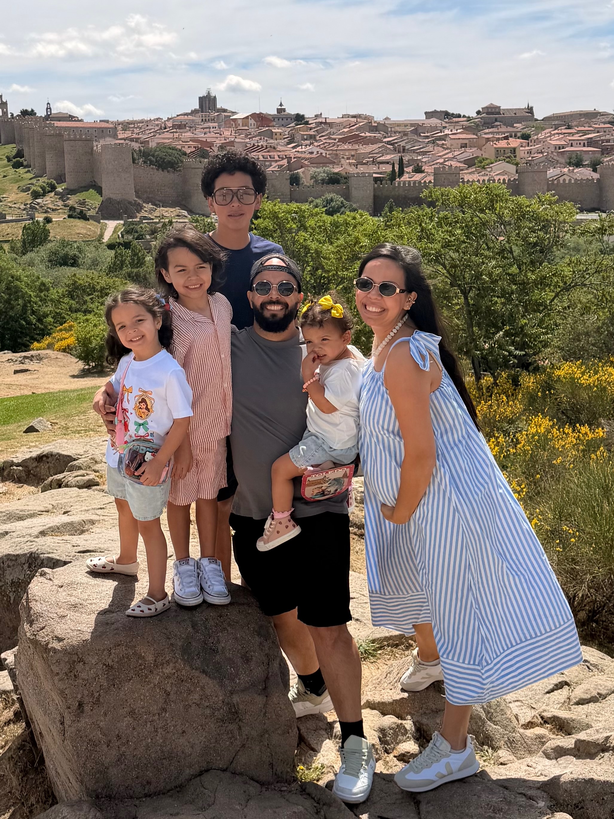 Anahely smiling with her husband and five children outdoors